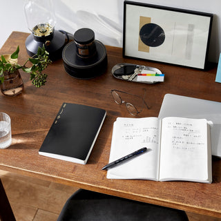 A dark wood desktop with STALOGY notebooks and pen on top. Very nice looking.