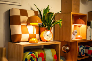 A view from the shop of a Peace Cabin cushion with Flowerpot lamp and Lemnos clock