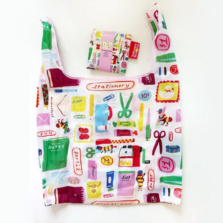 A reusable shopping bag with a colorful stationery-themed print, shown alongside a matching small pouch on a plain white background.