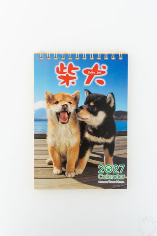 A 2027 Shiba Inu wall calendar featuring two Shiba Inu puppies on the cover