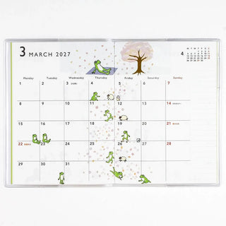 A6 monthly planner open to March 2027 calendar with frog and sheep icons