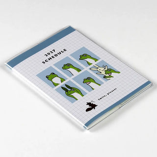 A6 monthly planner closed with blue top border and green frog graphic on cover