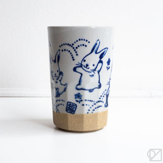 Ceramic cup with blue rabbit design on a white background