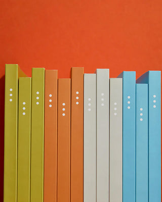 Colorful books arranged vertically against an orange background