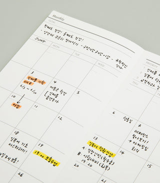 Calendar with handwritten notes and highlighted dates on a gray surface