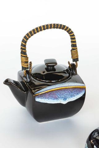 Black ceramic teapot with bamboo handle on a white background