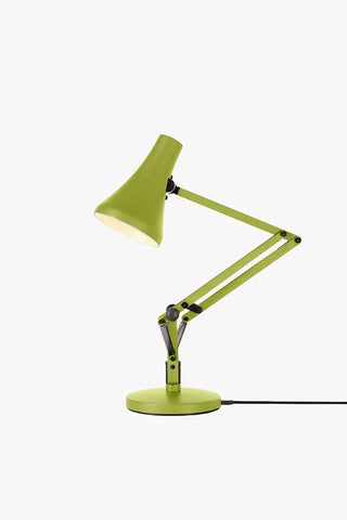 Green desk lamp with adjustable arm on a white background