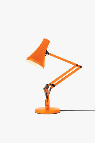 Orange desk lamp with adjustable arm on a white background