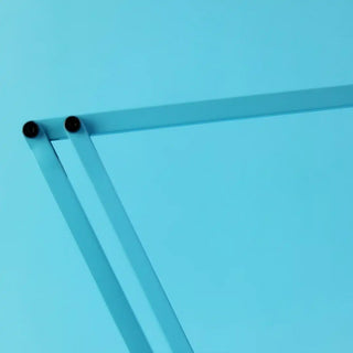 Close up of Anglepoise desk lamp on a solid blue background