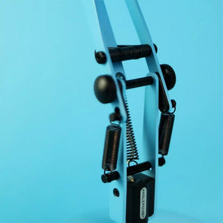 Close-up of mechanics of Anglepoise lamp with springs on a blue background