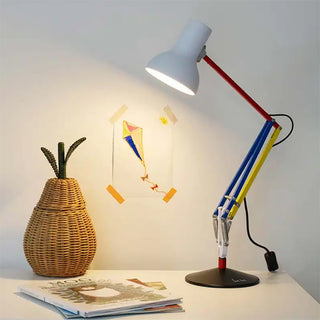 Colorful adjustable desk lamp on a table with a wicker vase and magazine in the background.