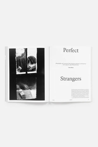 Magazine spread contains a black-and-white photographic print showing a person at a window and text on the right page