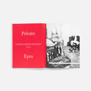 Open magazine with red page with text and a black and white photograph of the inside of a bedroom