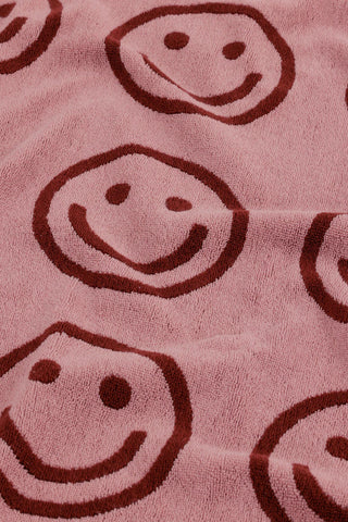close up of baggu bath towel with pink and red smiley face pattern