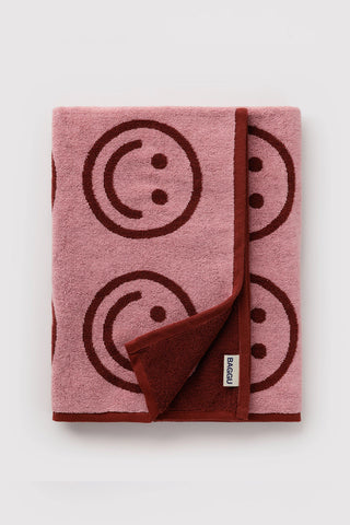 folded baggu bath towel with pink and red smiley face pattern