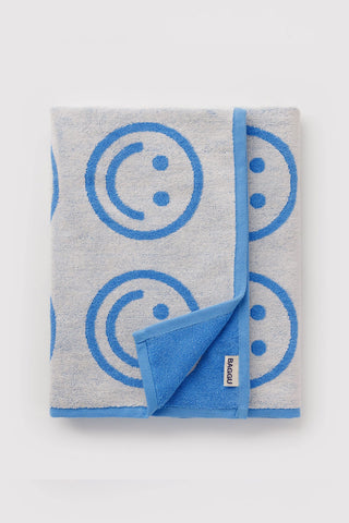 folded baggu towel with white and blue smiley face pattern