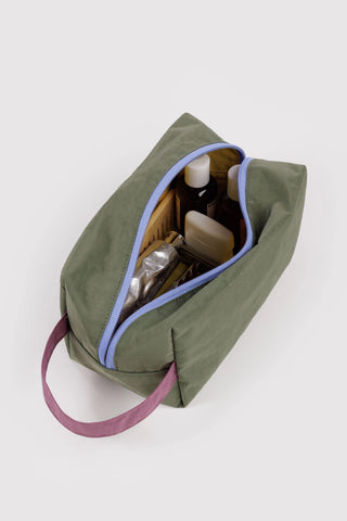 green baggu dopp kit with colorful accents with toiletry products inside