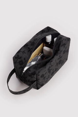 baggu dopp kit with black floral pattern with toiletry products inside