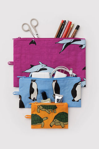Set of three zipper pouches with penguin and turtle designs on a white background. Stationery sticking out of one of the pouches