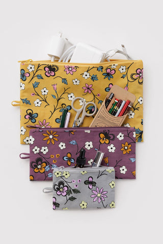 3 set of pouches in floral pattern with gray, purple, and yellow with various items inside