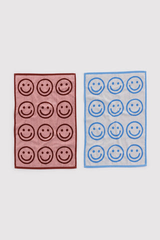 Set of baggu hand towels with smiley face pattern. one in red and pink colorway and other in blue and white colorway