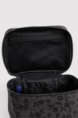 cosmetic case with handle in black floral pattern opened showing zipper compartment