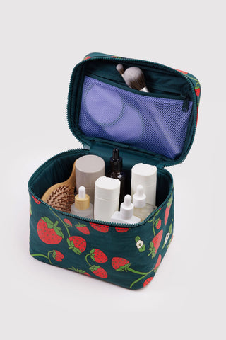 cosmetic case with zipper compartment inside and various beauty products in it in a strawberry pattern
