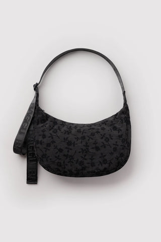 baggu medium crescent bag in black floral pattern on a light background