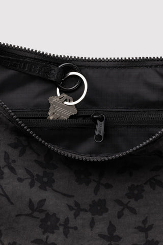 close up of inside zipper compartment with keys on baggu medium crescent bag in black floral pattern