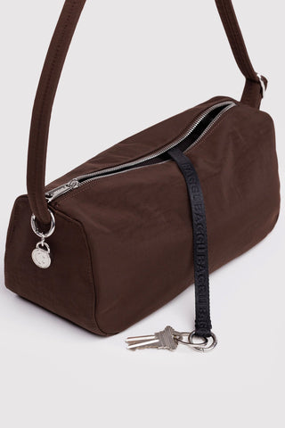 Brown handbag with a strap and keys on a white background