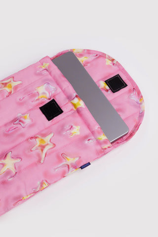 Pink pouch with star pattern containing a laptop on a white background