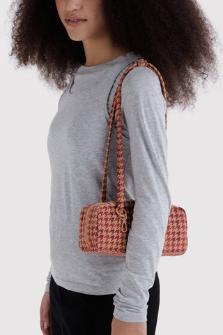 person wearing gray t shirt and wearing small bowler bag in tan houndstooth pattern on their shoulder