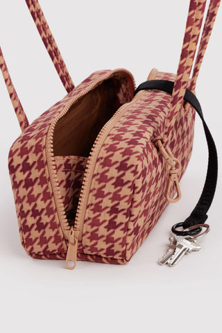 close up of opened small bowler bag in tan houndstooth pattern showing zipper and keychain compartments