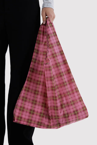 person holding pink, red, and green tartan patterned baggu tote  