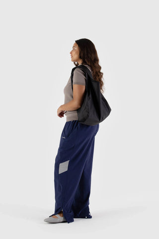 person wearing black baggu tote on their shoulder