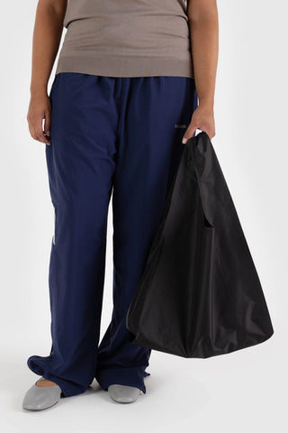 person holding black baggu tote on a light background