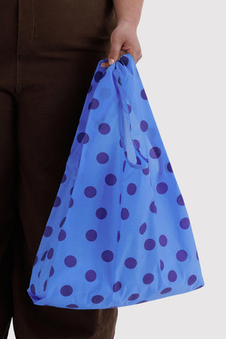 person holding blue polka dot baggu tote 