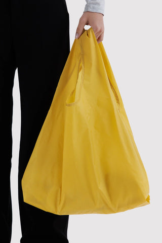 person holding yellow baggu tote 