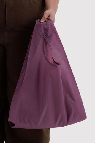 hand holding plum colored baggu tote 