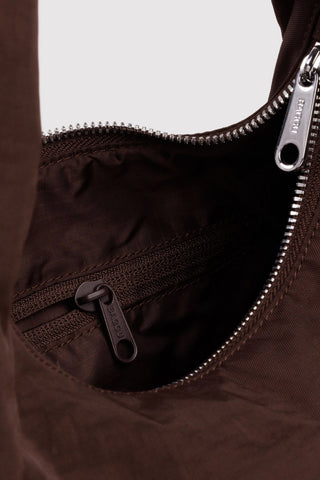Close-up of a brown bag with zippers on a light gray background