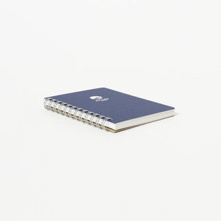 Blue notebook with a silver spiral binding on a white background