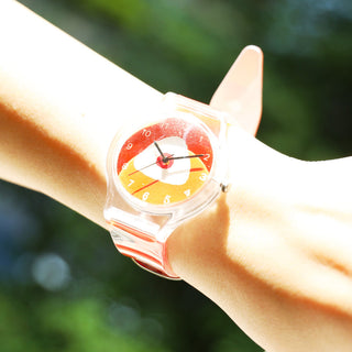 Colorful watch on a wrist with a blurred green background