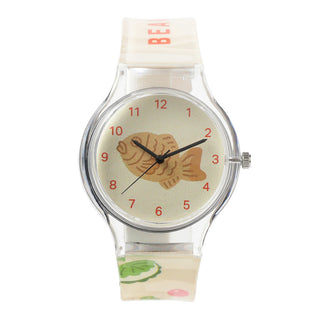 Watch with a fish dessert design on the dial against a white background