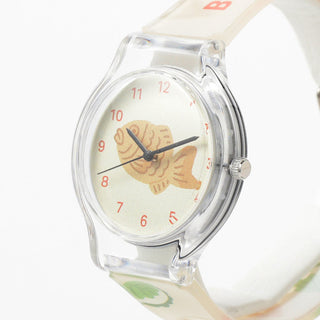 Wristwatch with a fish design on the dial against a white background