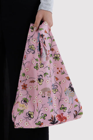 hand holding pink tote bag with flower and animals print