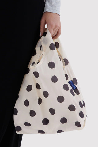 person holding tote bag with white and black polka dot print