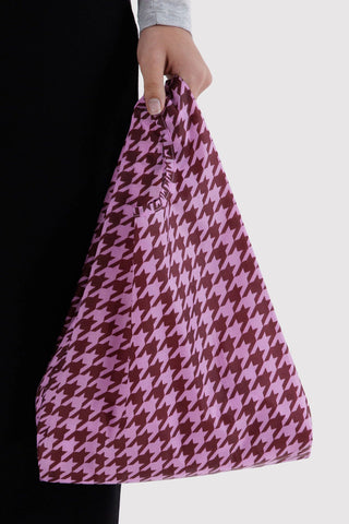 hand holding tote bag with pink and brown houndstooth pattern