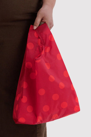 hand holding tote bag with red polka dot print