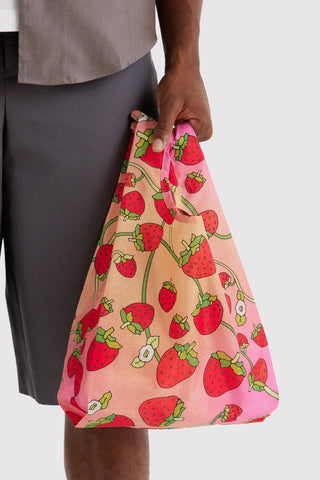Person holding tote bag with gradient and strawberry print