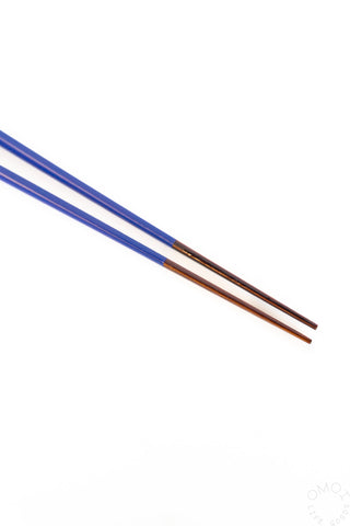 Two blue chopsticks on a white background